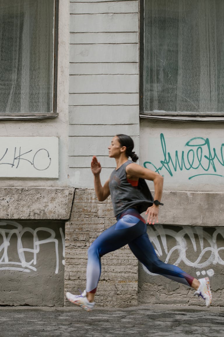 A Side View of a Woman Jogging on the Street