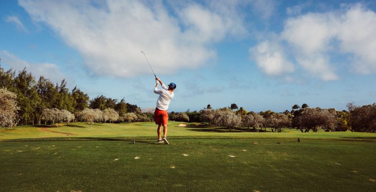 man in white t shirt playing golf