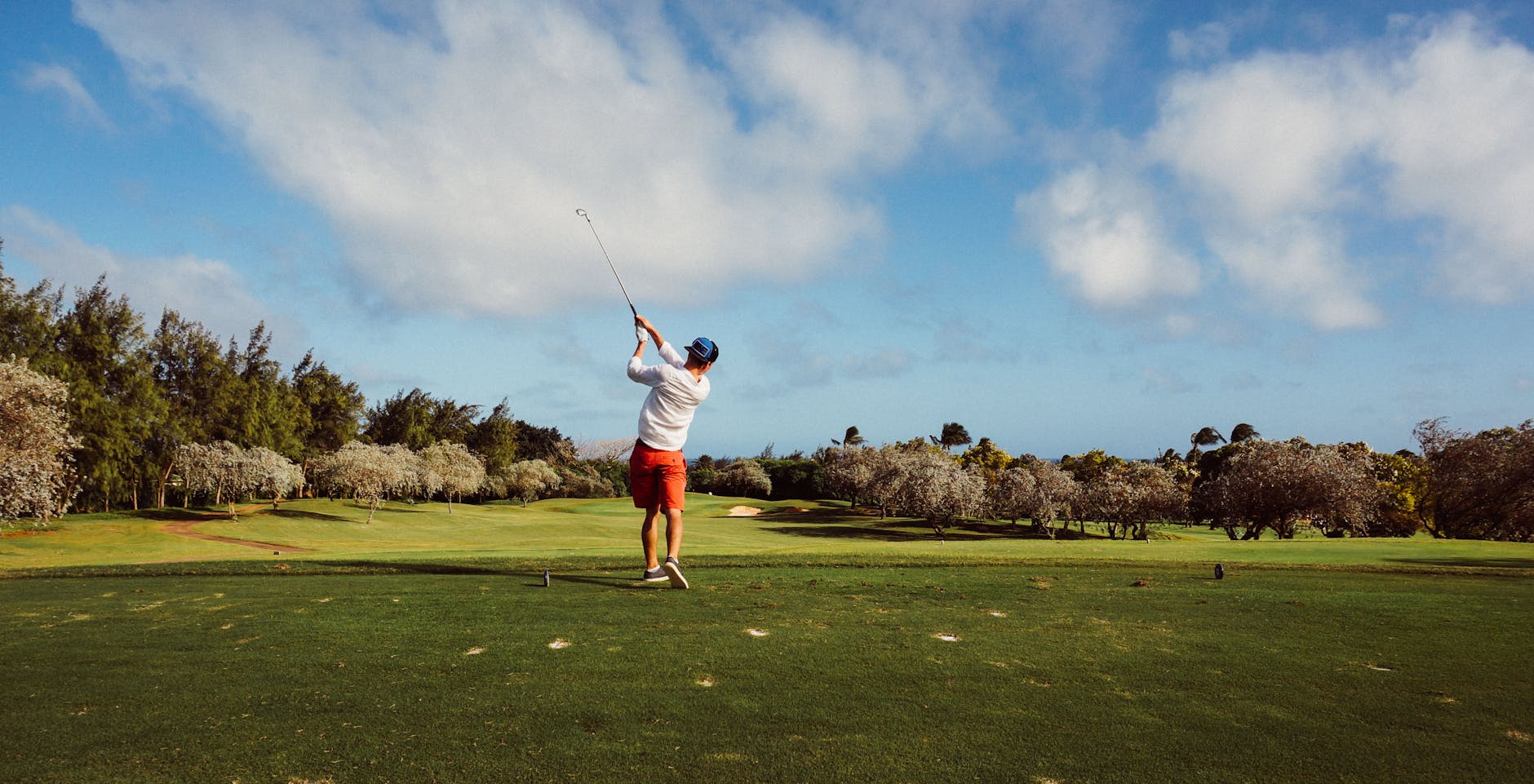 man in white t shirt playing golf